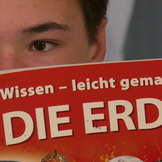 Jugendlicher liest in Themenheft "Die Erde"