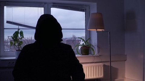 Person in dunklem Kapuzenpulli, von hinten aufgenommen.