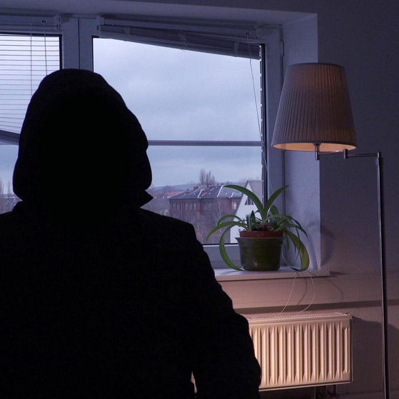 Person in dunklem Kapuzenpulli, von hinten aufgenommen.