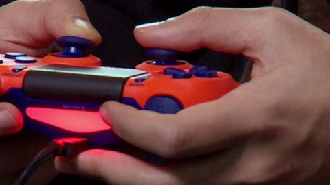 Aufnahme von Händen, die einen roten PS4 Controller halten.