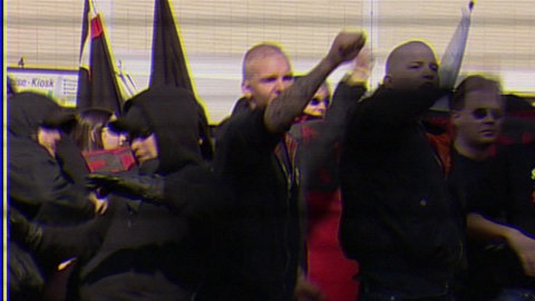 Demonstranten bei einer Versammlung von Neonazis mit Fahnen.