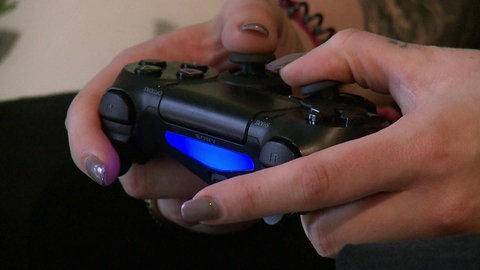 Frauenhände an Xbox-Fernbedienung.