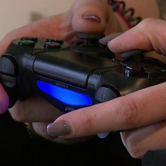 Frauenhände an Xbox-Fernbedienung.