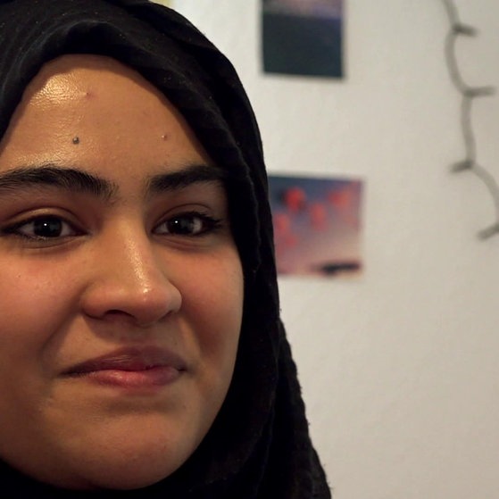 Junge Frau mit schwarzem Kopftuch.