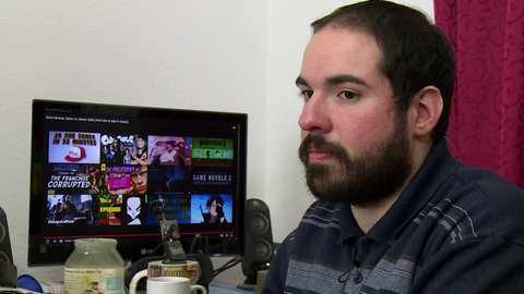 Gabriel neben einem Computerbildschirm.