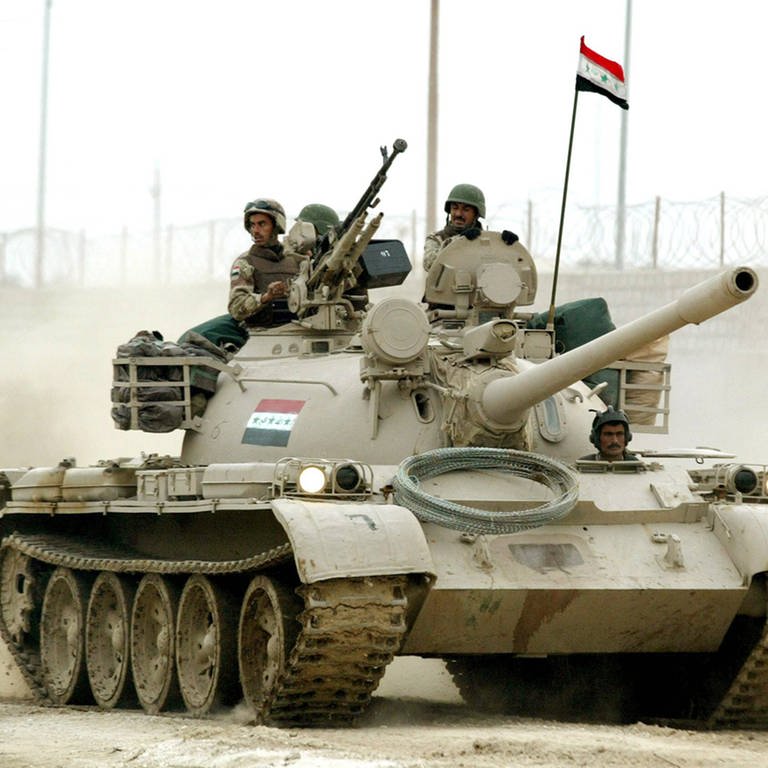 Ein Panzer fährt durch eine staubige Straße in Bagdad, zwei Soldaten schauen hinaus. Iternationale Krisen. (Foto: IMAGO / UPI Photo)