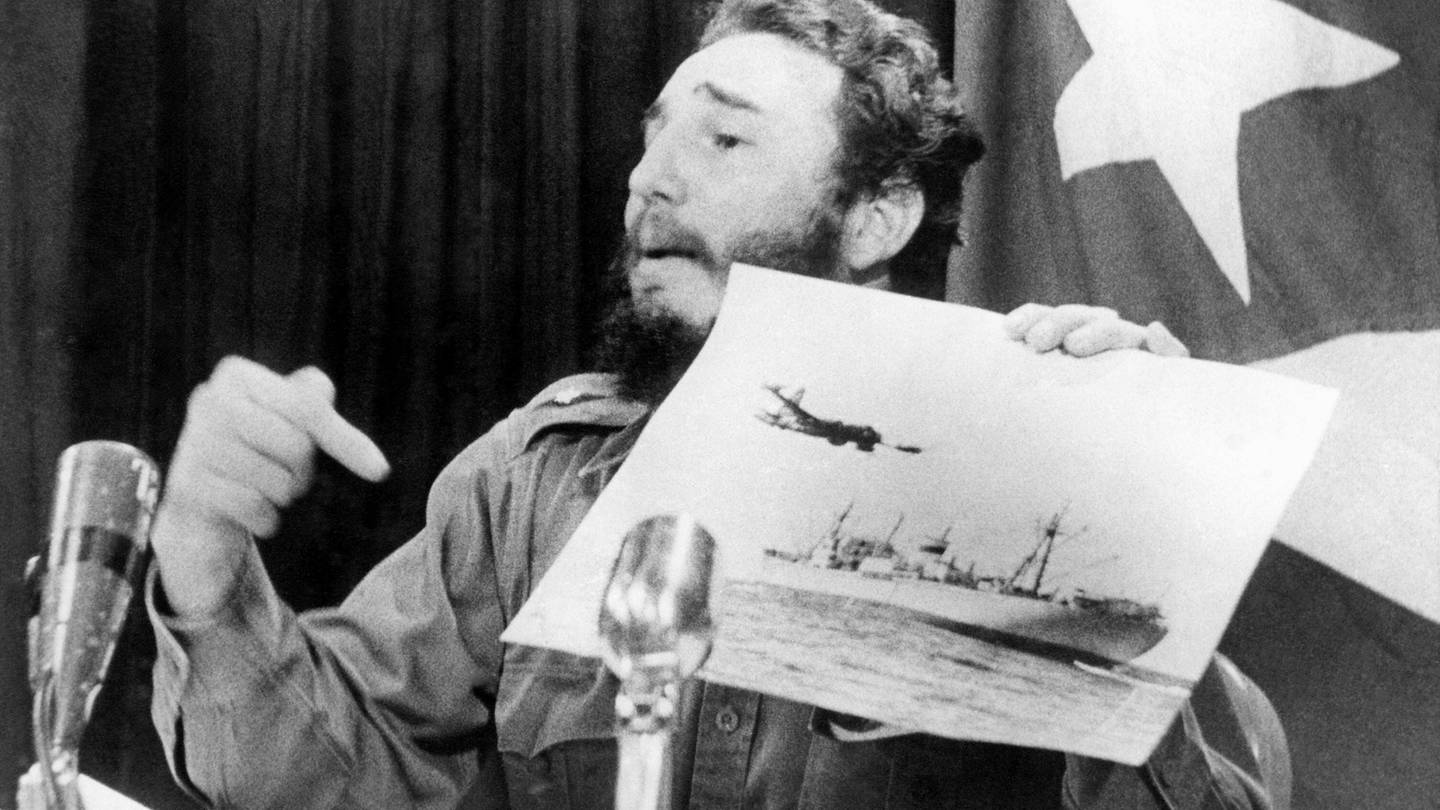 Fidel Castro deutet während der Kubakrise bei einem Fernsehauftritt auf ein Foto mit einem US-Aufklärungsflugzeugund einem sowjetischen Frachter.