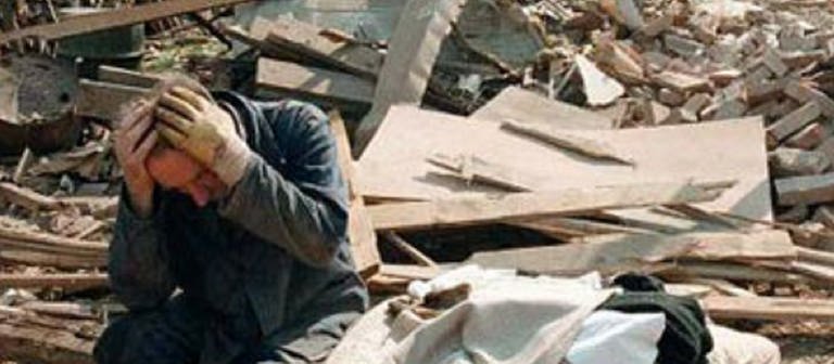 Ein verzweifelter Mann zwischen Trümmern (Foto: SWR – Screenshot aus der Sendung)