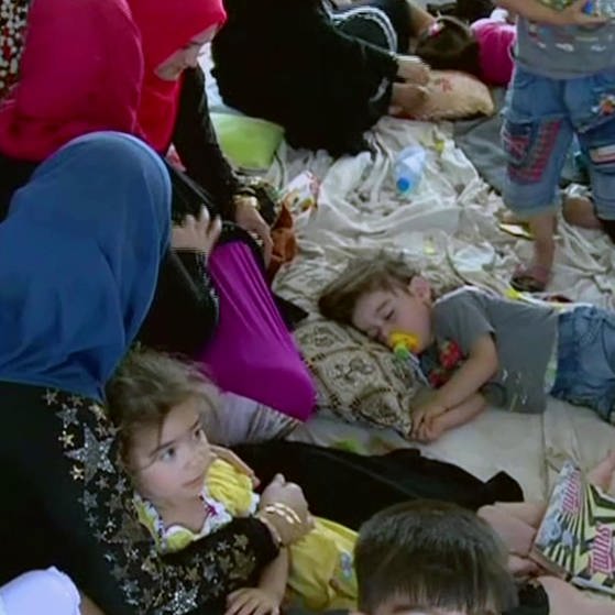 Geflüchtete Frauen und Kinder liegen und sitzen in einer Unterkunft auf dem Boden. (Foto: SWR – Screenshot aus der Sendung)