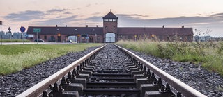Judenverfolgung: Ein Gleis führt Richtung Haupteingang des ehemaligen Konzentrationslagers Auschwitz