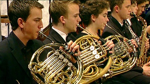 Zu sehen sind junge Hornisten beim Spielen des Instrumentes.