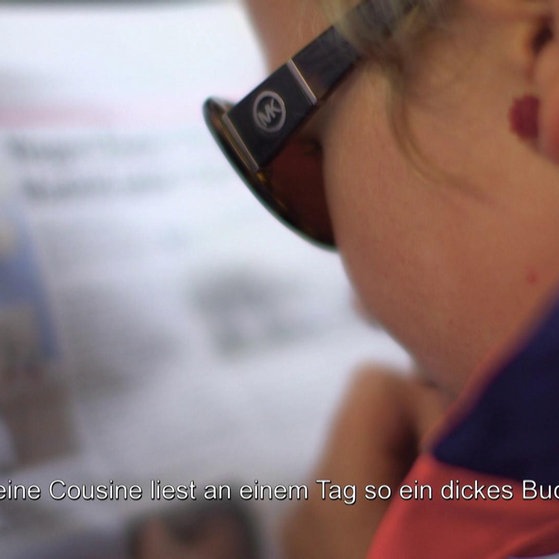 Rebekka liest mit Sonnenbrille eine Zeitschrift. (Foto: SWR – Screenshot aus der Sendung)