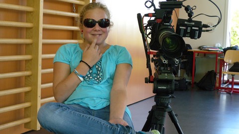 Rebekka in der Schulturnhalle vor der Kamera.