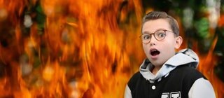 Ein überraschter Junge vor einem lodernden Feuer.