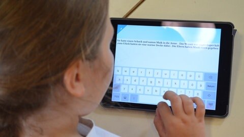 Mädchen schreibt auf Tablet