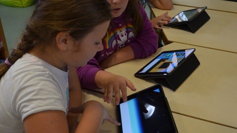 Schüler mit Tablets an einem Tisch