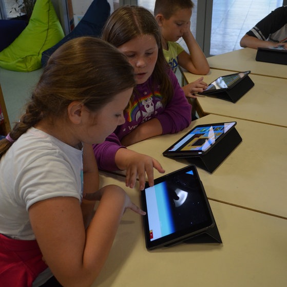 Schüler mit Tablets an einem Tisch