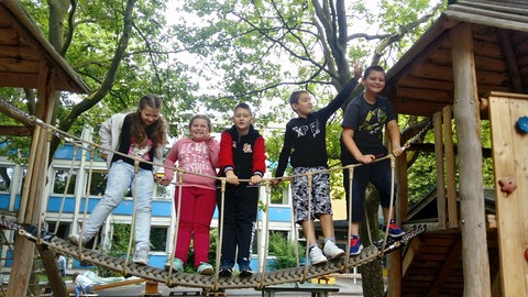 Fünf Kinder auf einer Spielplatz-Hängebrücke