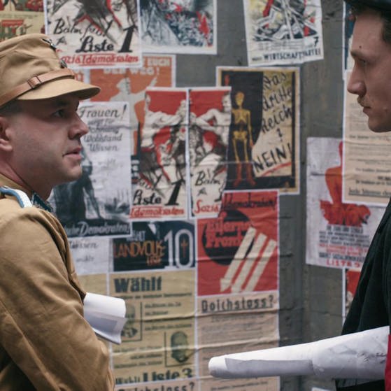 Spielszene: Hans Beimler (rechts) steht beim Plakatekleben einem Nationalsozialisten gegenüber. (Foto: SWR/arte/Co. – Screenshot aus der Sendung)