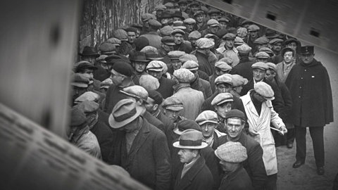 Historische Aufnahme: Dicht gedrängte Menge wartet vor einem Gebäude.