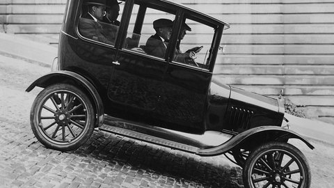 Ford-Modell T21, ein schwarz-weiß Foto eines altmodischen Autos, das eine steile Straße runterfährt.