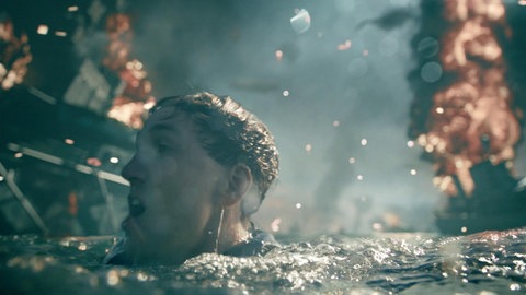 Filmszene: Jan Krauter als Matrose taucht zwischen brennenden Schiffen auf.