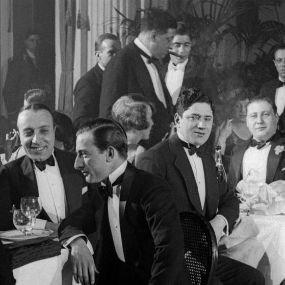 Förmlich gekleidete Männer und Frauen in Lokal.