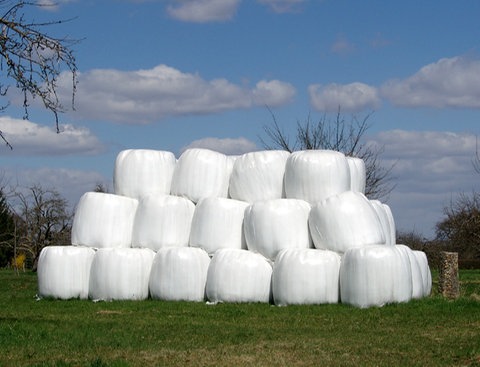 Ballen voller Silage auf einer Wiese gestapelt