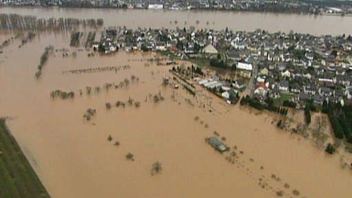 Luftaufnahme einer überfluteten Ortschaft am Rhein. (Foto: SWR – Screenshot aus der Sendung)