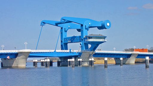 Eine moderne blau gestrichene Klappbrücke aus Metall auf Betonpfeilern im Wasser. (Foto: Peter Wiegel, www.pixelio.de)