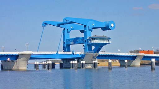 Eine moderne blau gestrichene Klappbrücke aus Metall auf Betonpfeilern im Wasser.