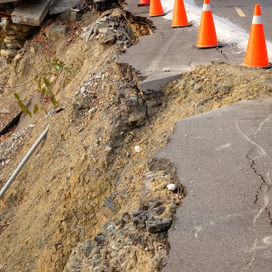Es ist eine Straße nach einem Erdrutsch zu sehen, die mit Leitkegeln gekennzeichnet ist. (Foto: Colourbox)