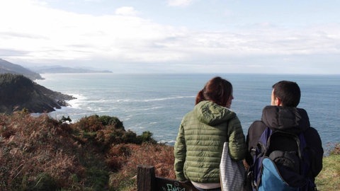 Zwei Menschen stehen an der Küste.