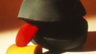 Ein grünes Wesen leckt an einer gelben Rolle