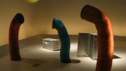 Drei Röhren spielen mit einem Ballon.