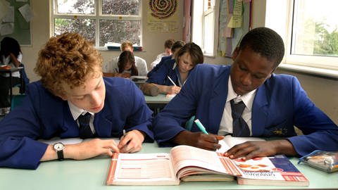Blick in eine englische Schulklasse: Zwei Schüler arbeiten mit einem Schulbuch