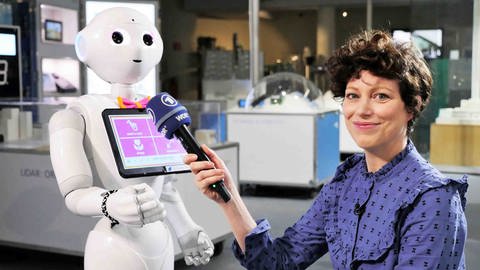 neuneinhalb-Reporterin Malin hält dem humanoiden Roboter 'Pepper' ihr Mikro hin. (Foto: WDR, tvision)