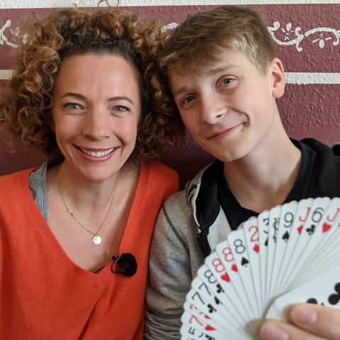 neuneinhalb-Reporterin Gesa zusammen mit Timm, der einen Kartenfächer in der Hand hält (Foto: WDR, tvision)