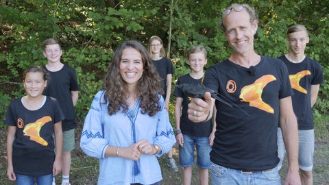 neuneinhalb-Reporterin Mona mit einer Gruppe Jugendlicher, den ICARUS-Botschafter*innen, und Wissenschaftler Dr. Jesko Partecke. Der Wissenschaftler hält in der Hand eine Amsel mit dem ICARUS-Sender auf dem Rücken.