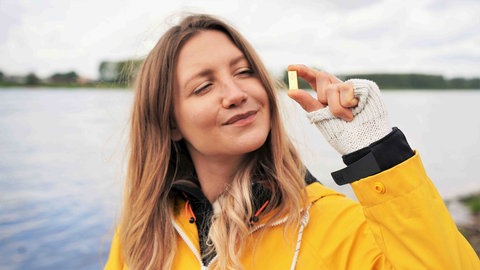 neuneinhalb-Reporterin Jana hält einen kleinen Goldbarren in der Hand.