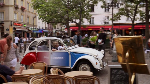 2CV in Frankreichfarben fährt durch Paris.