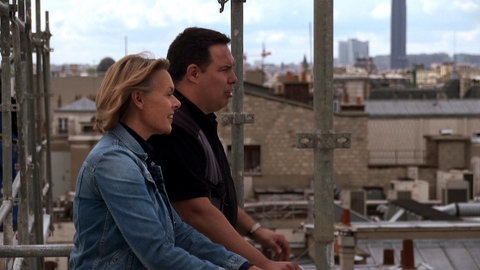 Ute Brucker mit Dachdecker an einem Gerüst auf dem Dach.