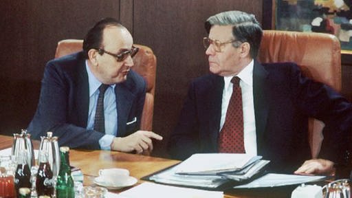 Außenminister Hans-Dietrich Genscher (links) und Bundeskanzler Helmut Schmidt (rechts) im Gespräch am Sitzungstisch