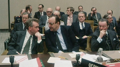 Sitzungssaal: am Tisch sitzend für Deutschland: Verteidigungsminister Hans Apel und Außenminister Hans-Dietrich Genscher; dahinter Vertreter anderer Nationen