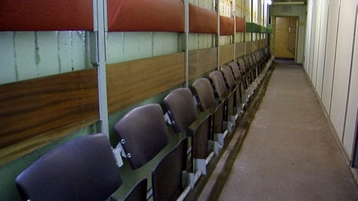 Atombunker Dortmund innen: schmaler Gang mit Klappsitzen