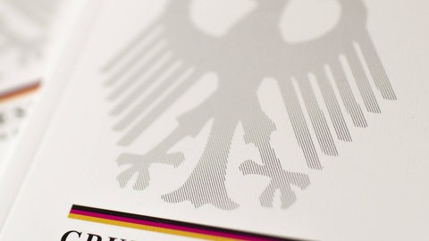 Mehrere Ausgaben des Grundgesetzes liegen übereinander.