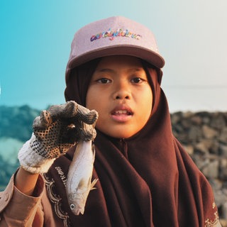 Nina hält einen toten Fisch in der Hand