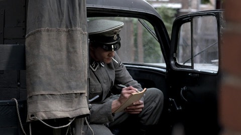 Felix Landau sitzt in Lkw und schreibt ins Tagebuch.