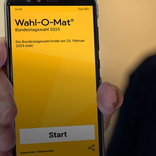 Person hält ein Smartphone mit Wahl-o-Mat-Bild.