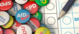 Bunte Buttons von Parteien auf Wahlzettel